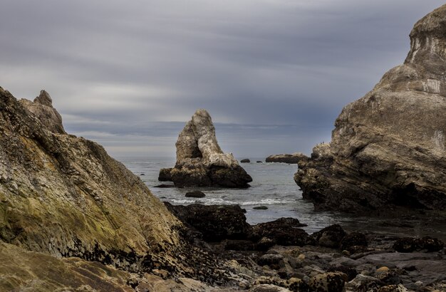 Fascinante vista de las rocas en el océano bajo el cielo azul