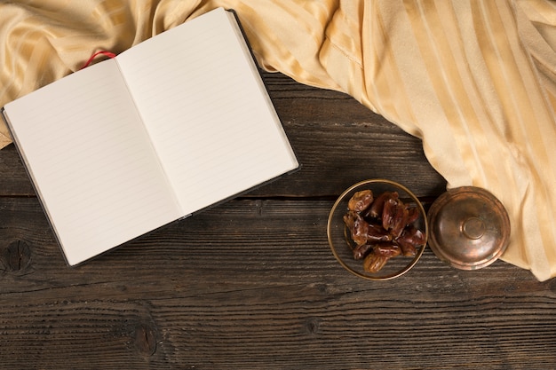 Fechas de frutas en un tazón con cuaderno en blanco