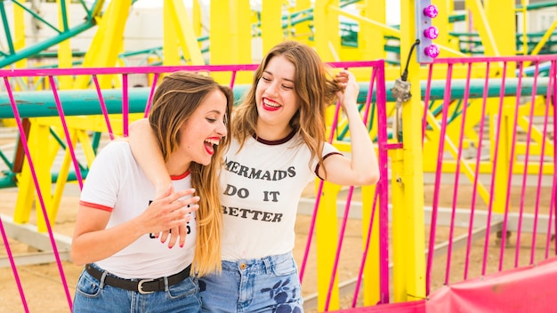 Felices amigas divirtiéndose en el parque de atracciones