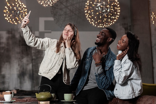 Felices amigos multiculturales tomando selfie