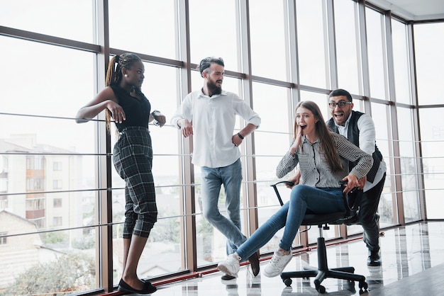 Felices colegas jóvenes sonríen y se divierten en la oficina creativa.