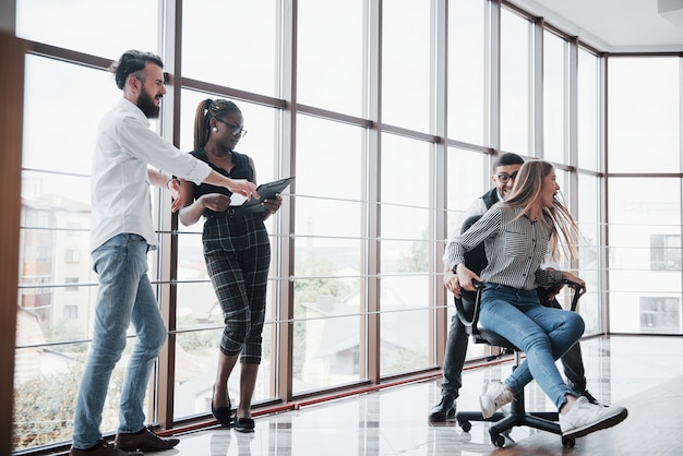 Felices colegas jóvenes sonríen y se divierten en la oficina creativa.