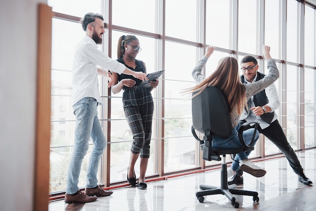 Felices colegas jóvenes sonríen y se divierten en la oficina creativa.