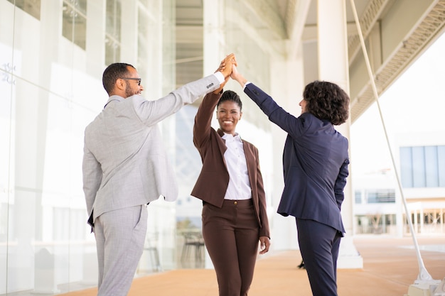 Felices colegas de negocios alegres celebrando el éxito