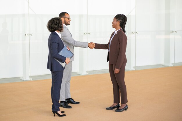 Felices colegas de negocios dándose la bienvenida