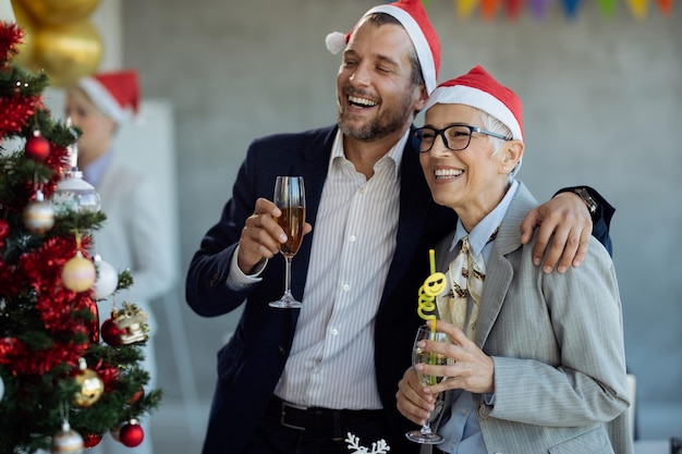 Felices colegas de negocios divirtiéndose mientras celebran la Navidad en la fiesta de la oficina