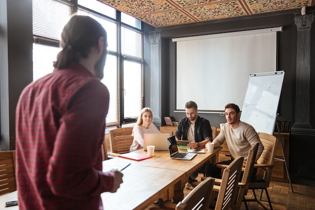 Felices colegas sentados en la oficina y coworking