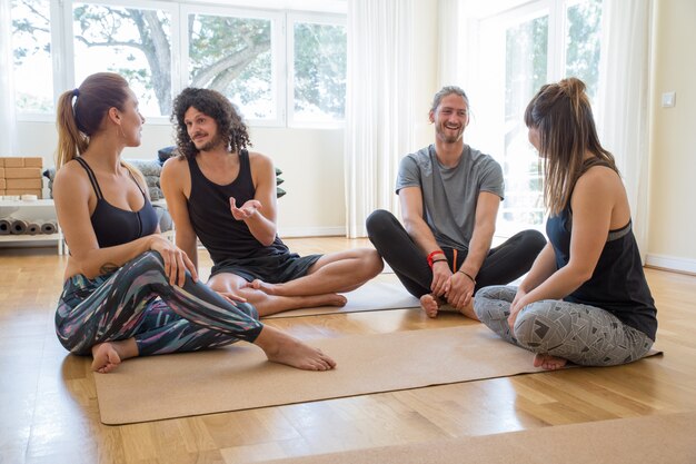 Felices estudiantes charlando después de la clase de yoga