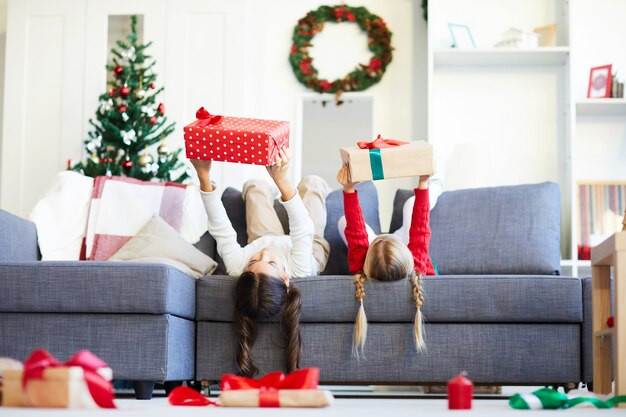 Felices hermanas niñas desenvolver regalos de Navidad