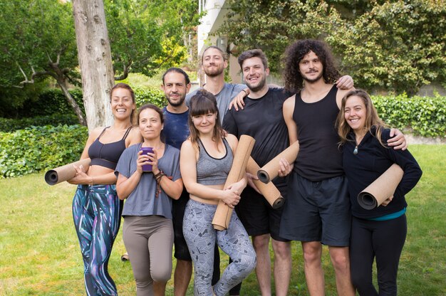 Felices hombres y mujeres del club de yoga divirtiéndose