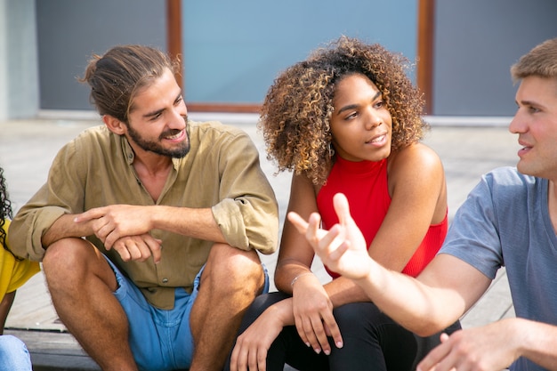 Felices jóvenes amigos hablando al aire libre