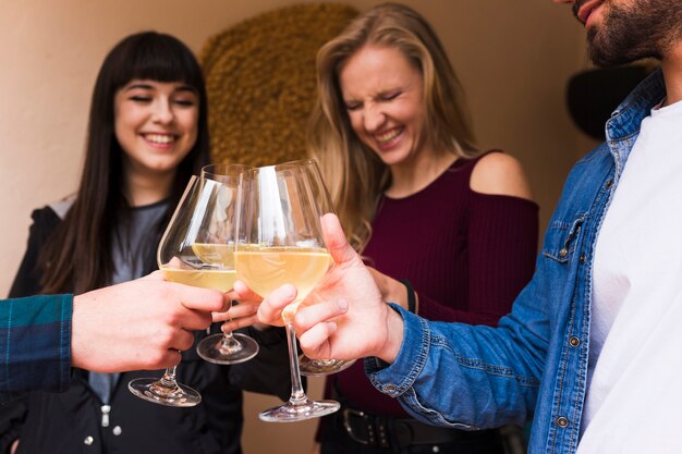 Felices jóvenes amigos con vaso de alcohol en la mano