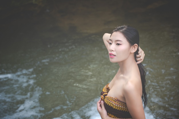 Foto gratuita felices mujeres bañándose en la cascada natural.