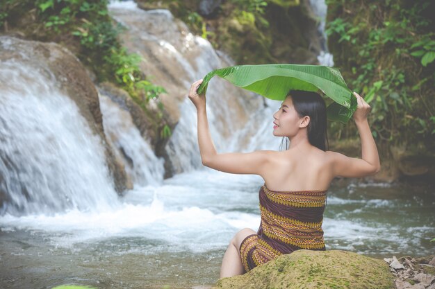 Felices mujeres bañándose en la cascada natural.