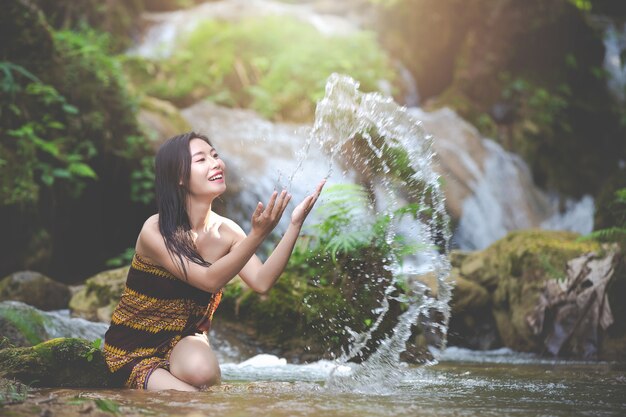 Felices mujeres bañándose en la cascada natural.