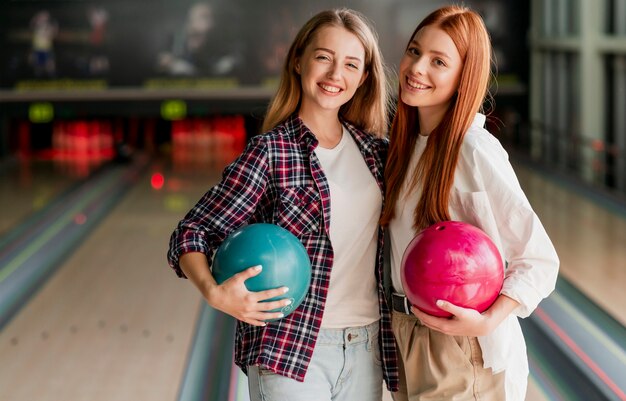 Felices mujeres jóvenes posando en un club de bolos