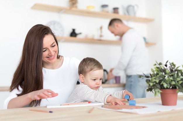 Felices padres en la cocina con niño