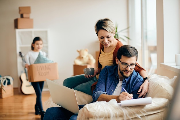 Felices padres con hija mudándose a un nuevo apartamento