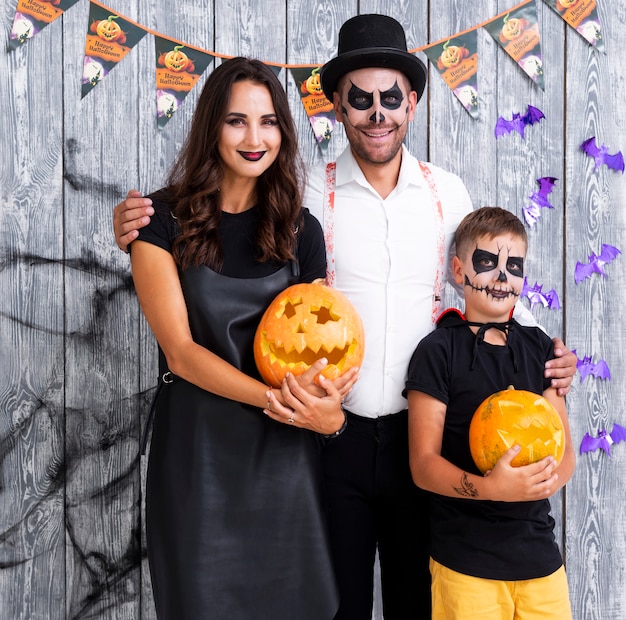 Felices padres con hijo posando para halloween