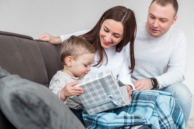 Felices padres en el sofá con bebé