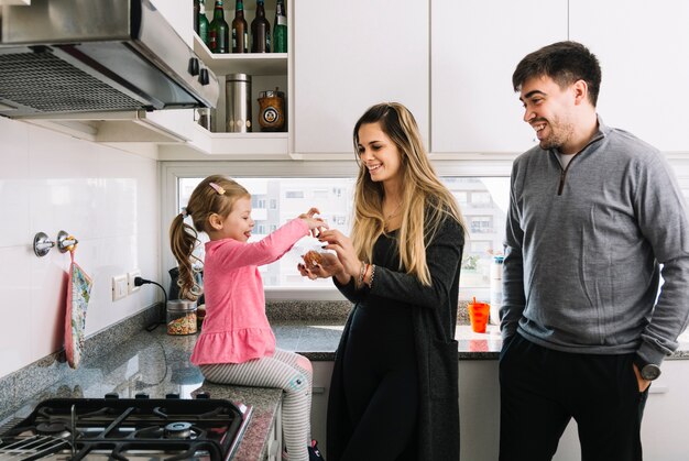 Felices padres con su hija en la cocina