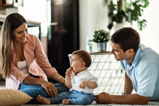 Felices padres y su pequeño hijo disfrutando en familia en su casa