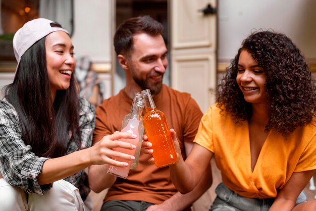 Felices tres amigos brindando por sus bebidas