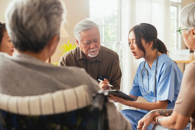 Felicidad Alegre anciana y hombres hablando con una enfermera cuidadora médica que tiene una consulta de control de salud en la sala de estarCuidadores con una pareja mayor sentada en la sala de estar en un hogar de ancianos