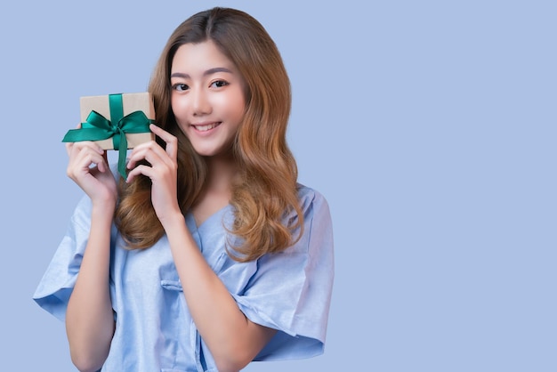 Felicidad alegre paciente asiática o mujer enferma en uniforme de hospital sonrisa y caja de regalo de mano con cinta sonrisa expresión facial seguro apoyo y promoción