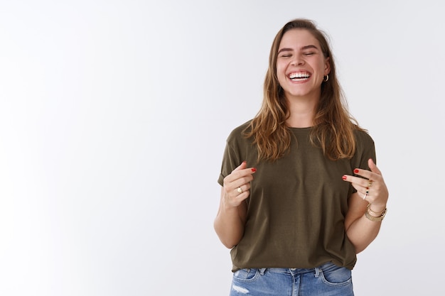 Foto gratuita felicidad, deleite, concepto de bienestar. atractiva mujer positiva encantadora despreocupada divirtiéndose riendo a carcajadas sinceras ojos cerrados diciendo jaja gesticulando escuchando broma hilarante, riendo entre dientes