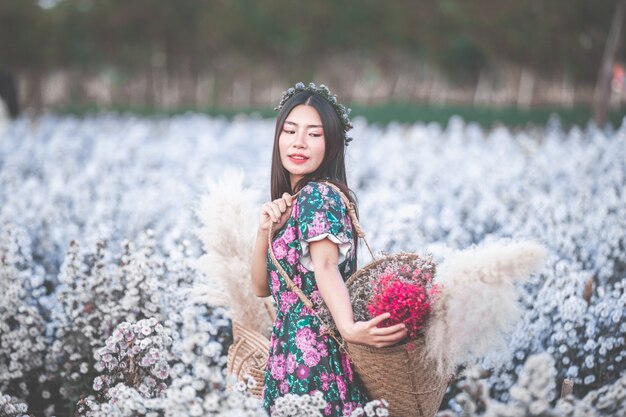 felicidad hermosa mujer sosteniendo cesta de flores en jardín de flores