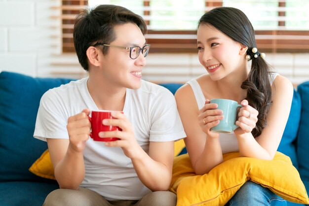 Felicidad pareja asiática familia casarse disfrutar de la mañana junto con el amor y la relación en el fondo interior del hogar del sofá