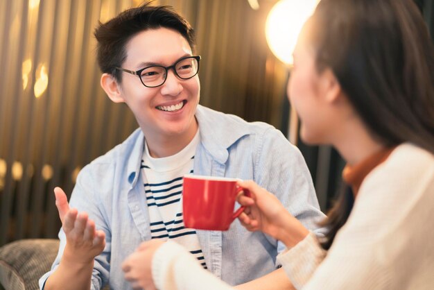 Felicidad pareja asiática risa sonrisa junto con en la cocina despensa humor emocional casual relajarse con fondo interior de la habitación