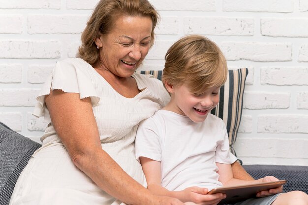 Feliz abuela y niño con tableta