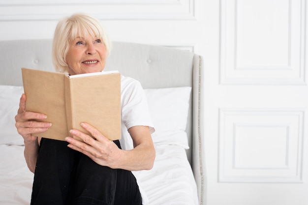 Feliz anciana sosteniendo un libro