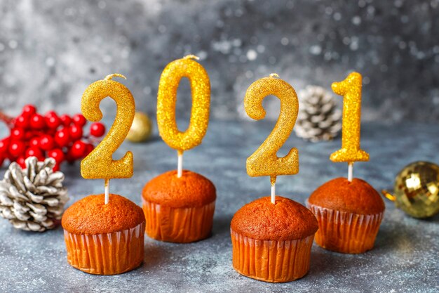 Feliz año nuevo 2021, cupcakes con velas doradas.