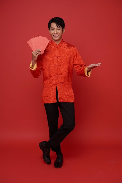 Foto gratuita feliz año nuevo chino 2024 hombre asiático con ropa tradicional roja sosteniendo angpao