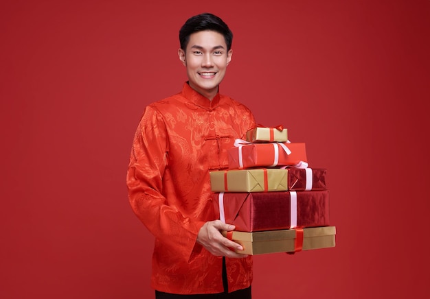 Foto gratuita feliz año nuevo chino sonriente hombre asiático con traje tradicional dando caja de regalo dorada