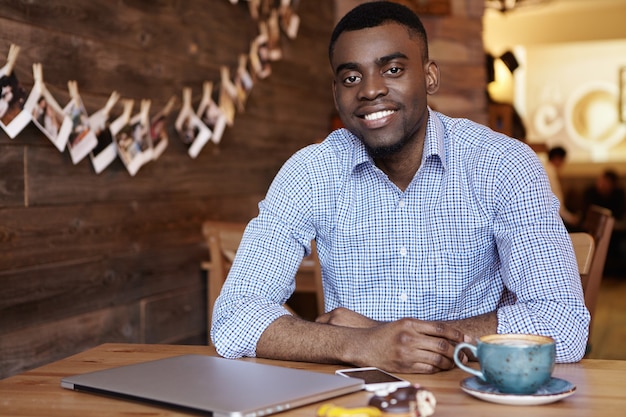 Feliz apuesto joven empresario afroamericano vestido con camisa