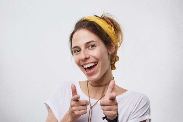 Feliz apuntando a la cámara y sonriendo.