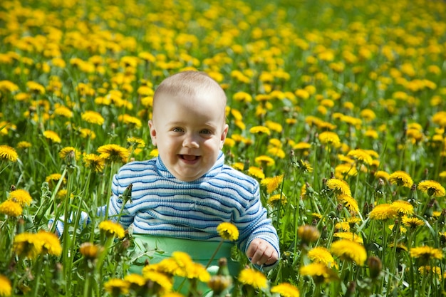 Feliz bebé en el prado de flores