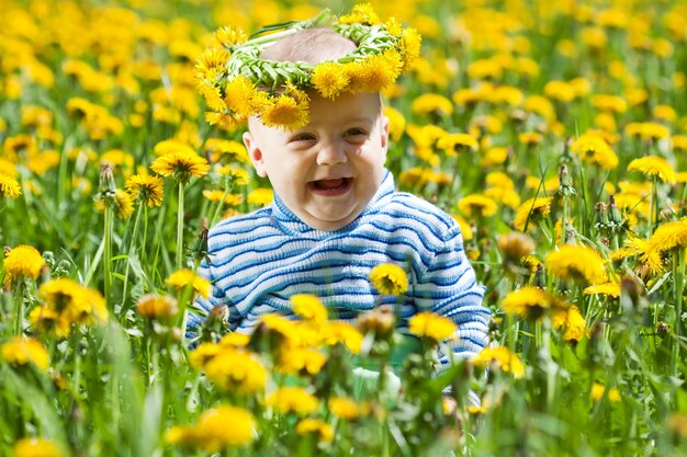 Feliz bebé en el prado de flores