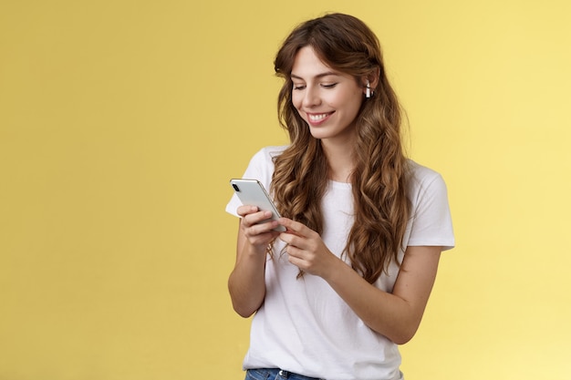 Feliz cariñosa tierna novia femenina pelo largo rizado sostenga smartphone recogiendo canción escuchar camino a casa ...