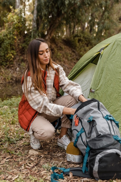 Feliz chica de camping en el bosque de embalaje