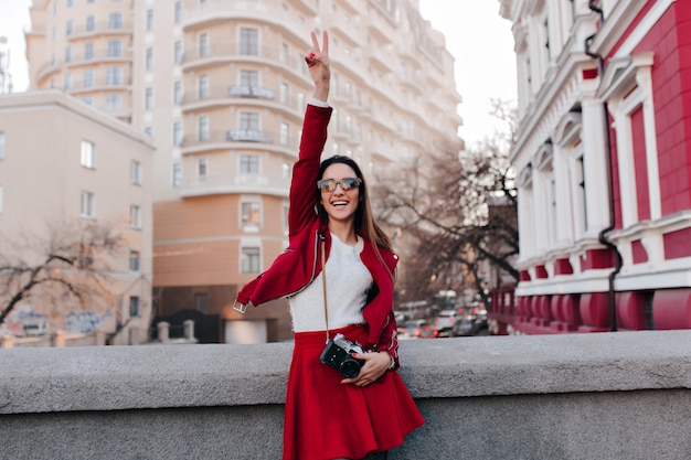 Feliz chica morena disfrutando de un buen día durante la sesión de fotos