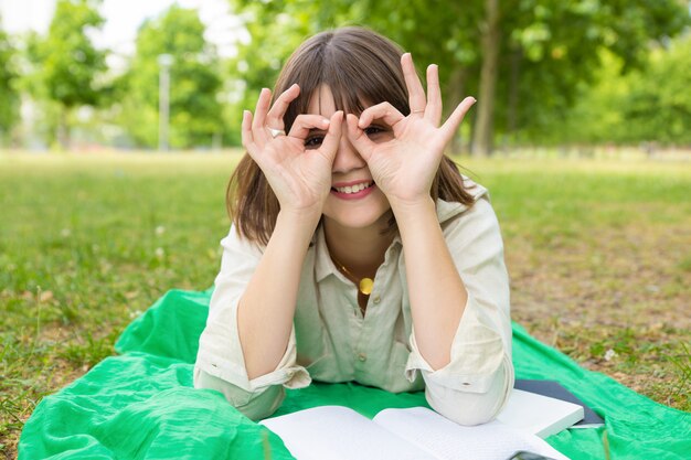 Feliz chica universitaria despreocupada haciendo muecas por la cámara