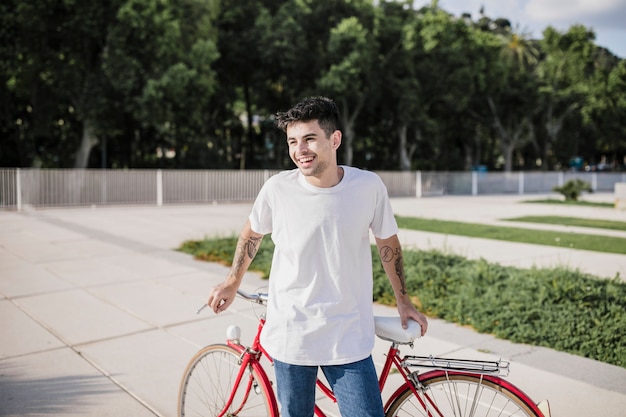 Feliz ciclista posando delante de su bicicleta