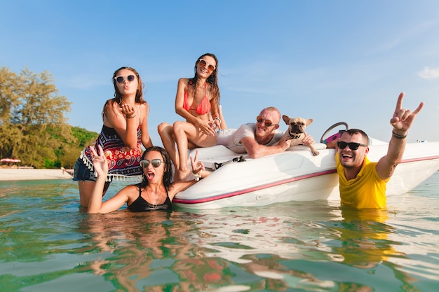 Feliz compañía de amigos en vacaciones tropicales de verano en Tailandia viajando en barco en el mar, fiesta en la playa, gente divirtiéndose juntos, emociones positivas de hombres y mujeres