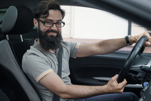 Feliz conductor de automóvil con cinturón de seguridad abrochado