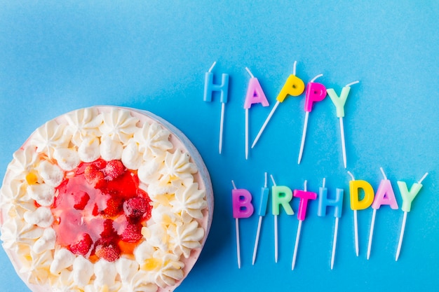 Feliz cumpleaños escribiendo de velas y pastel